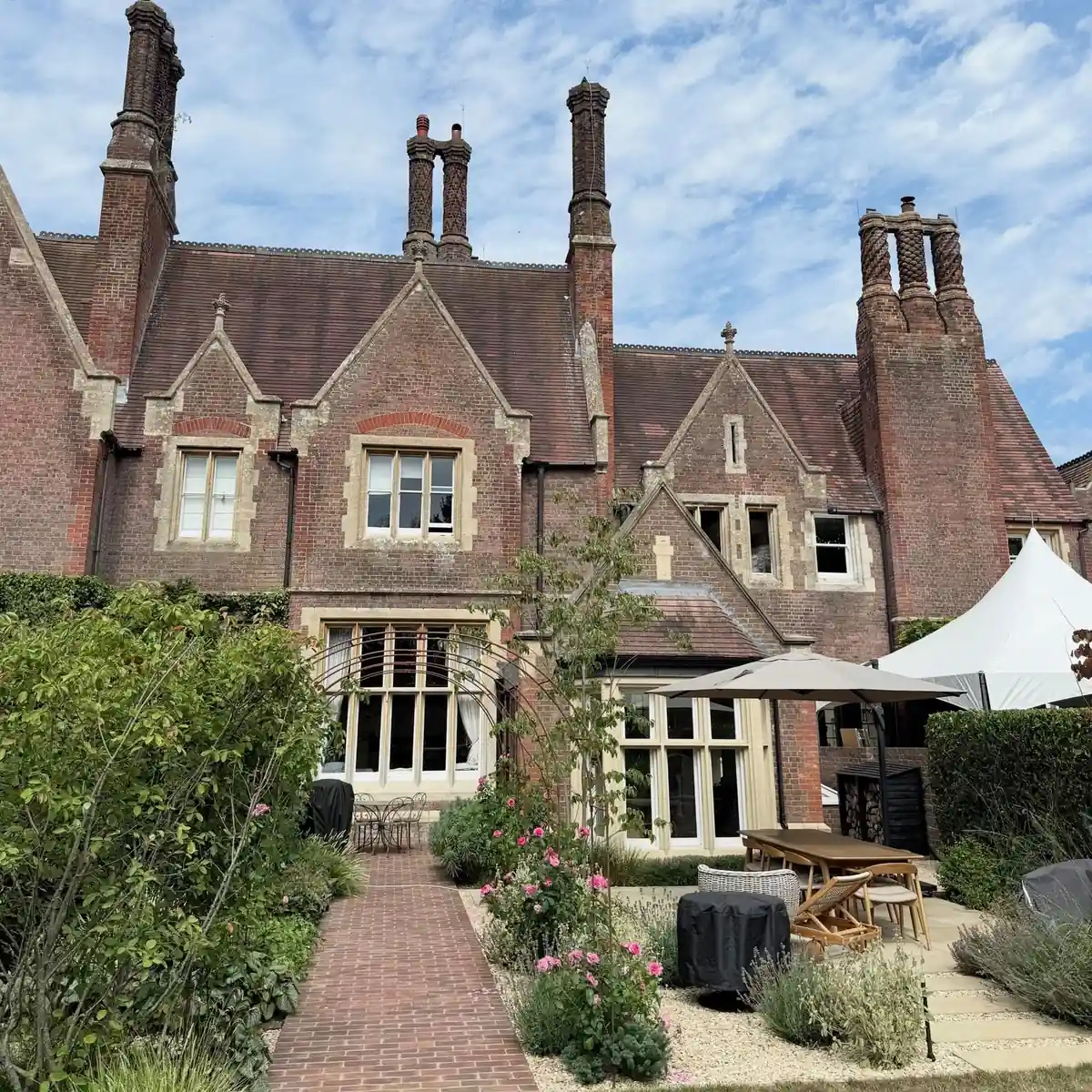 A Grade II listed brick house with gables, tall chimneys and timber windows