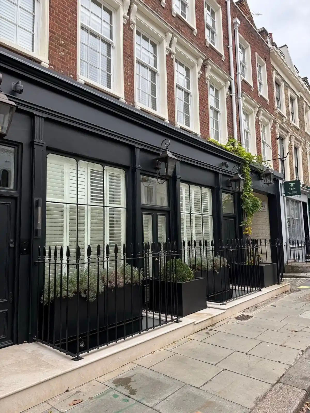 A black-painted Grade II listed timber shop front in Maida Vale