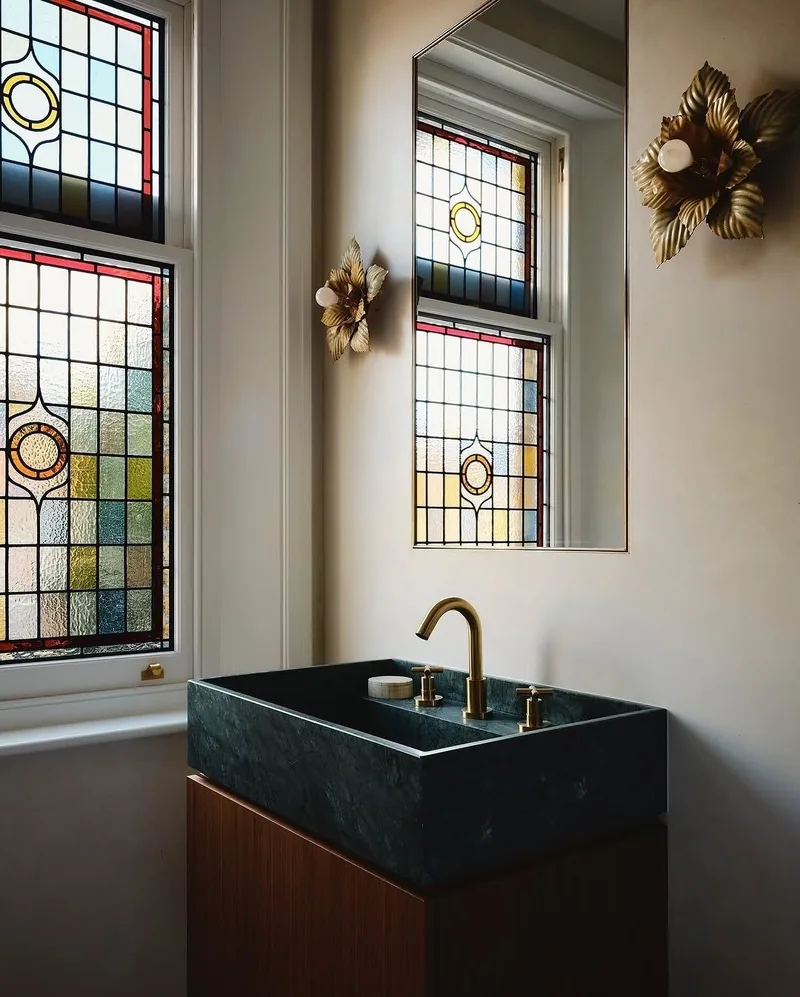 Stained-glass upper lights above a timber window in a cloakroom