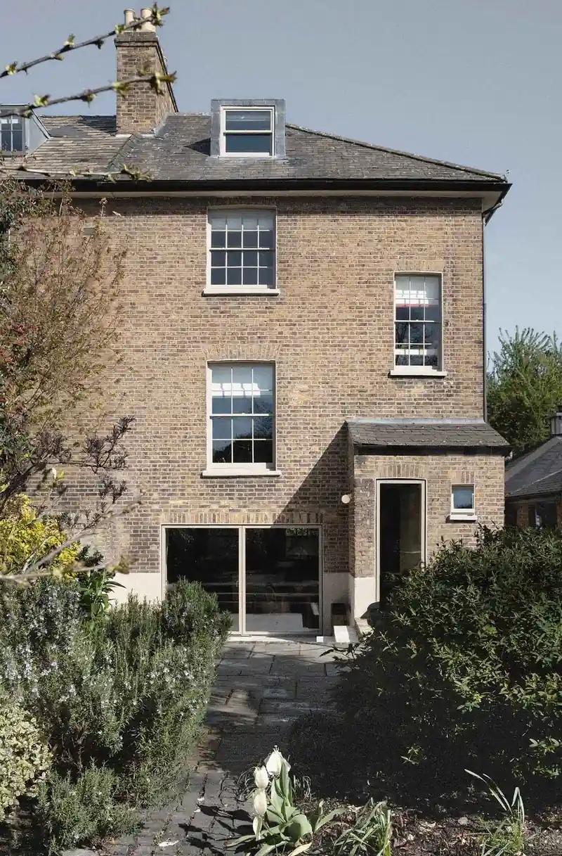 The rear of a stock-brick villa with white timber sash windows